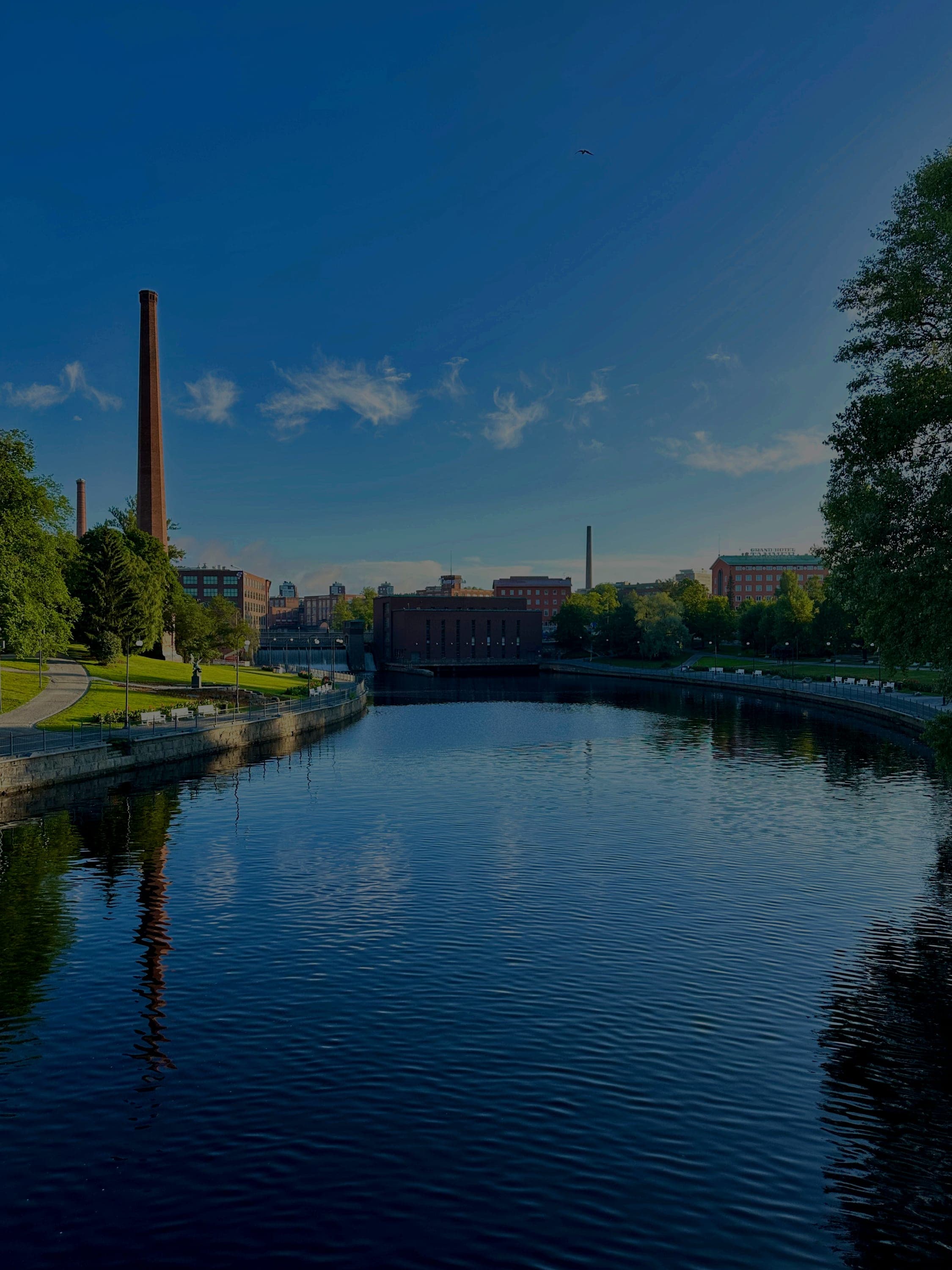 Tammerkosken rantaa ja tehtaan piippu illan hämärässä